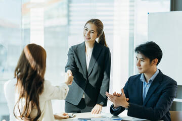 Group of asian young modern people in smart casual wear having a brainstorm meeting while sitting in office background. Business meeting, Planning, Strategy, New business development, Startup concept.