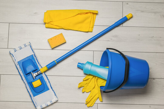 Scattered cleaning tools on the wooden floor. The concept of maintaining cleanliness. Flat lay.