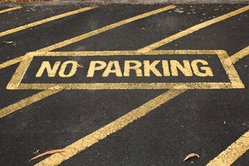 No parking sign painted in yellow on the pavement
