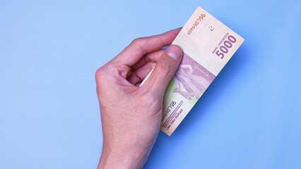 Indonesian Rupiah the official currency of Indonesia. Man's hand is making a payment. Business Loan...