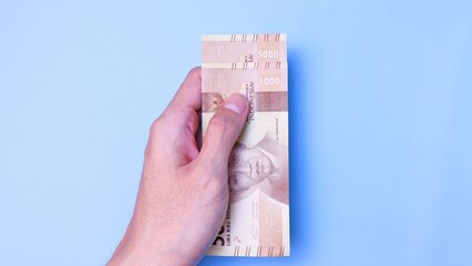 Indonesian Rupiah the official currency of Indonesia. Man's hand is making a payment. Business Loan...