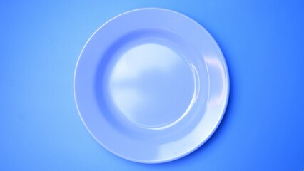 Empty blue plate on blue background with space for your meal. Food and beverage concept. Food Photography. High angle view. Top view. Flat Lay.