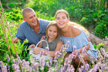 Fototapeta premium Parents and their daughter spending time together in their garden