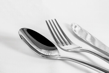 Closeup of a set of shiny silverware on white background with copy space.