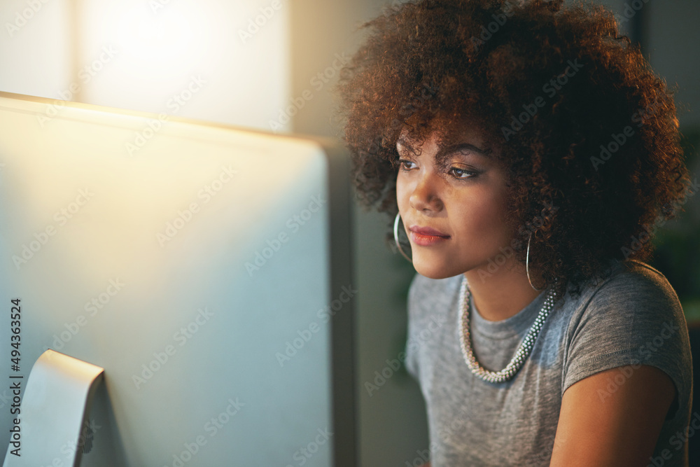 Poster staying one step ahead of the deadline. shot of a young woman using a computer during a late shift a