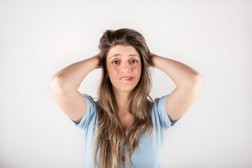 Fototapeta premium Blond woman clutching her head, puzzled expression