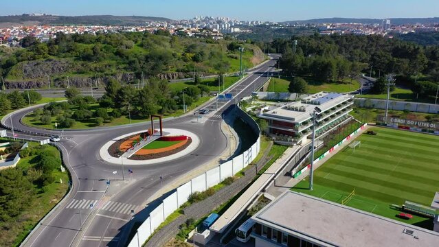 Aerial view around a traffic circle, at the Cidade do Futebol, in sunny Lisbon - circling, drone shot