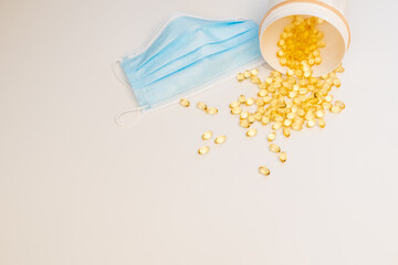 covid-19 theory, vitamin d with surgical mask and pills spilling from bottle