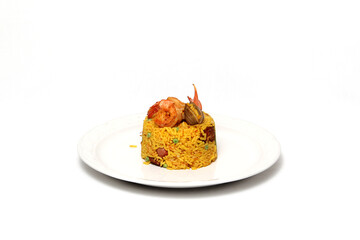 Paella rice is a traditional cuisine recipe from the city of Valencia Spain prepared with saffron, seafood, shrimp, vegetables served on a white plate
