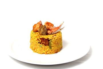 Paella rice is a traditional cuisine recipe from the city of Valencia Spain prepared with saffron, seafood, shrimp, vegetables served on a white plate
