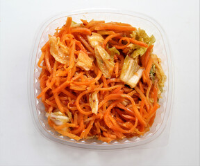 Chinese cabbage kimchi in a plastic container. Kimchi with carrots, cabbage, spices.