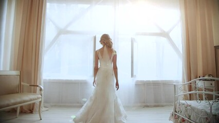 beautiful bride walks slowly to the window