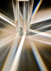 Close up image of group of crystal clear triangular glass prisms refracting and scattering beam of...