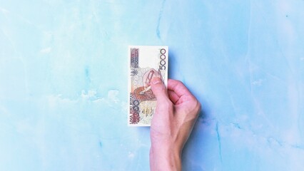 Indonesian Rupiah the official currency of Indonesia. Man's hand is making a payment. Business Loan...