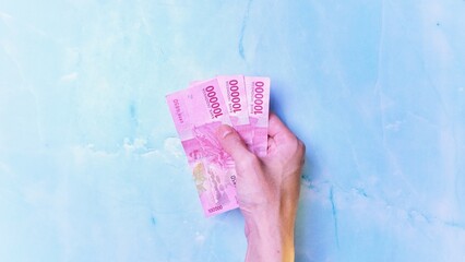 Indonesian Rupiah the official currency of Indonesia. Man's hand is making a payment. Business Loan...