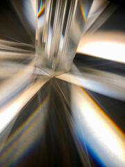 Close up image of group of crystal clear triangular glass prisms refracting and spreading a ray of...