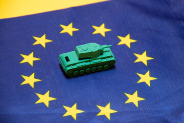 Ivanovo, Russia - 03.03.2022: selective focus on miniature of real tank on flag of  European Union:...