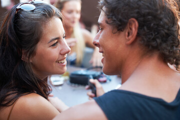 Naklejka premium Hes such a charmer. Young teen couple sharing a romantic moment while out with their friends.