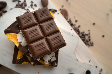 Raw Vegan Handmade Chocolate with dried mango fruits and coconuts slices close up. Chocolate bar with mango on a light background