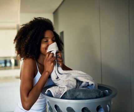 The Fragrance Of Fresh Clothing. Cropped Shot Of An Attractive Young Woman Smelling Clean Laundry At Home.