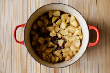 Top view of cut up apples and raisins cooked in a pot. Making apple-raisins filling.