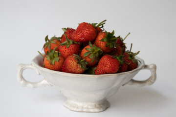 Close up Fresh organic Strawberries in a white bowl, white background