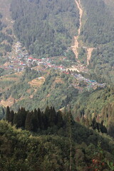 forest covered himalayan foothills and mountain village mane bhanjang from simana basti view point, at nepal india border, darjeeling, west bengal, india