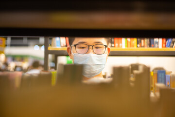 asian young university school research student with face masks read books in book shop or library during Covid-19 in Hong Kong