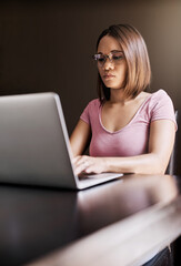 Its easier for her to concentrate on work at home. Cropped shot of an attractive young businesswoman working from home.