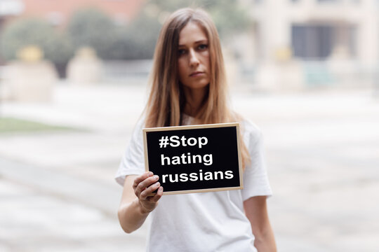 Young Caucasian Activist Woman Holding Banner With Inscription Stop Hating Russians