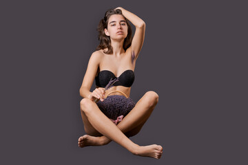 Girl in shorts sticks out them lavender like pubic hair. Symbol stubble and problems with home depilation. Razor near excess hair. Body positivity and body hair problems. On a black background - obrazy, fototapety, plakaty