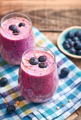 Blueberry smoothie in glass. Homemade blueberry smoothie on rustic wooden table. Blueberry smoothie with yogurt and oats.