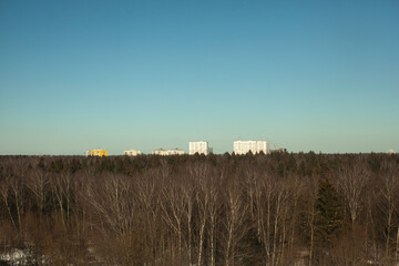 View over forest. Houses on horizon. Open space.