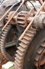 Fototapeta na wymiar brown rusty heavy gears of an old gearbox in closeup