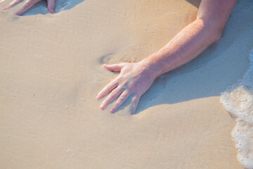 Fototapeta na wymiar sandy shore and a man is hand