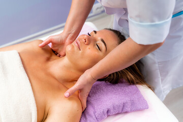 Obraz na płótnie Canvas Facial massage. A woman is given a massage in a beauty salon. Close-up.