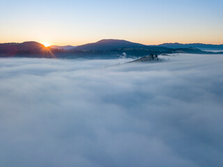 Sunrise over the fog in the Ukrainian Carpathians. Aerial drone view.
