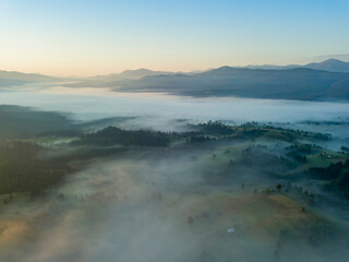 Green mountains of the Ukrainian Carpathians in the morning mist. Aerial drone view.