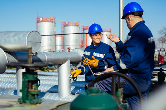 Two Engineers Working Inside Oil And Gas Refinery