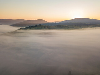 Sunrise over the fog in the Ukrainian Carpathians. Aerial drone view.