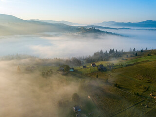 Green mountains of the Ukrainian Carpathians in the morning mist. Aerial drone view.