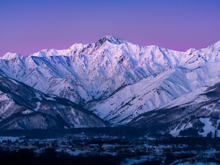 日の出前の紫色のビーナスベルトで空と山肌が染まる、北アルプス静な時間帯。