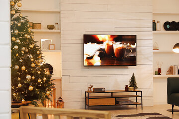 Plasma TV on white wooden wall in living room beautifully decorated for Christmas