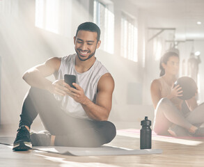 This app helps me to stay on track with my fitness goals. Shot of a man using his cellphone while on a break at the gym.