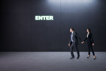 Thoughtful young businesspeople standing in concrete interior with entrance to success. Way and...