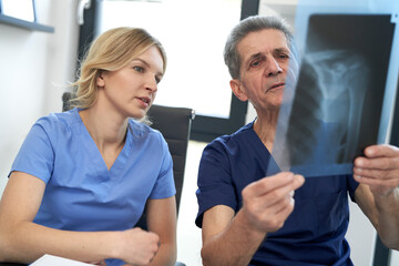 Fototapeta premium Two caucasian doctors discussing abut X-ray image