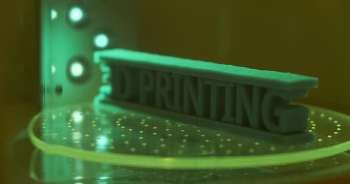 Close up 3D printing object text being cure in resin curing station, Post processing of consumer resin 3D printing. 