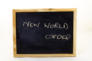 Obraz premium The term new world order written on a small chalkboard with copy space