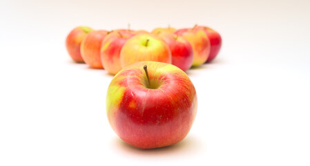 Apples in a triangle and one apple on a white background. Emulation of billiards. Selective focus.