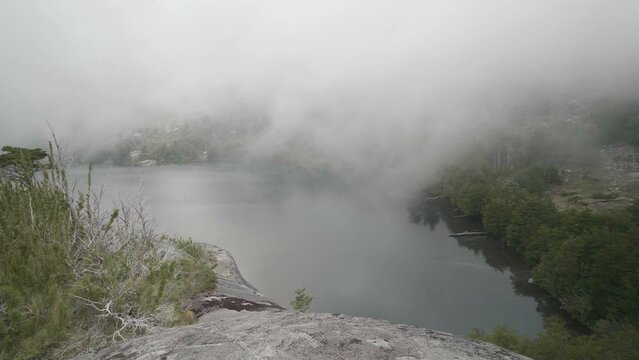 Clouds passing through a lake. Light rain on the distance.